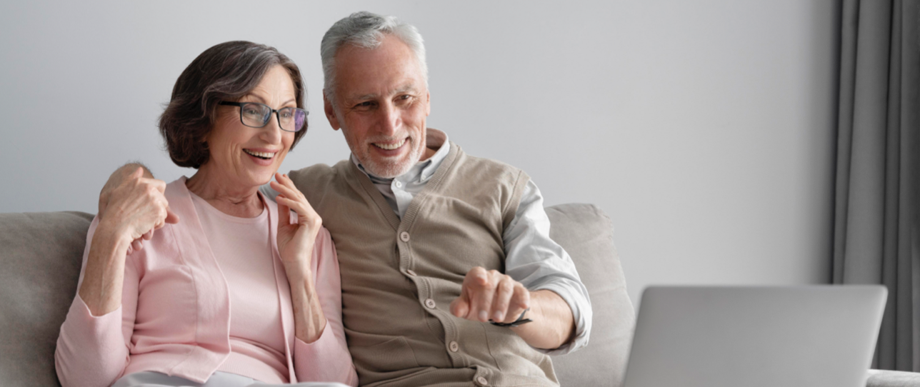 Couple de personnes âgées qui regardent un ordinateur