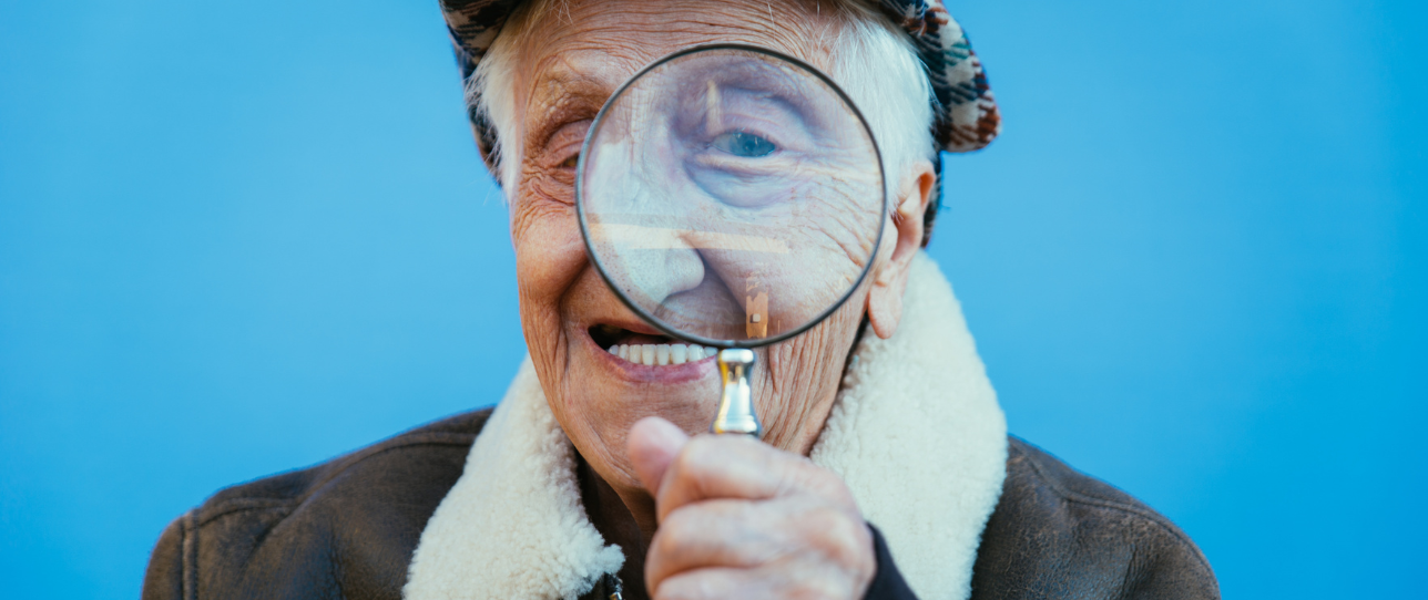 Senior souriant avec une loupe à la main